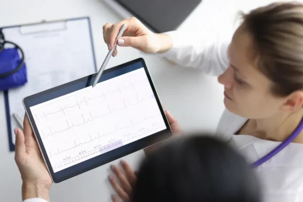 EKG technician using tablet to review data
